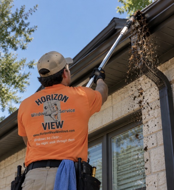 Horizon View technician safely clearing roof gutters on a ladder